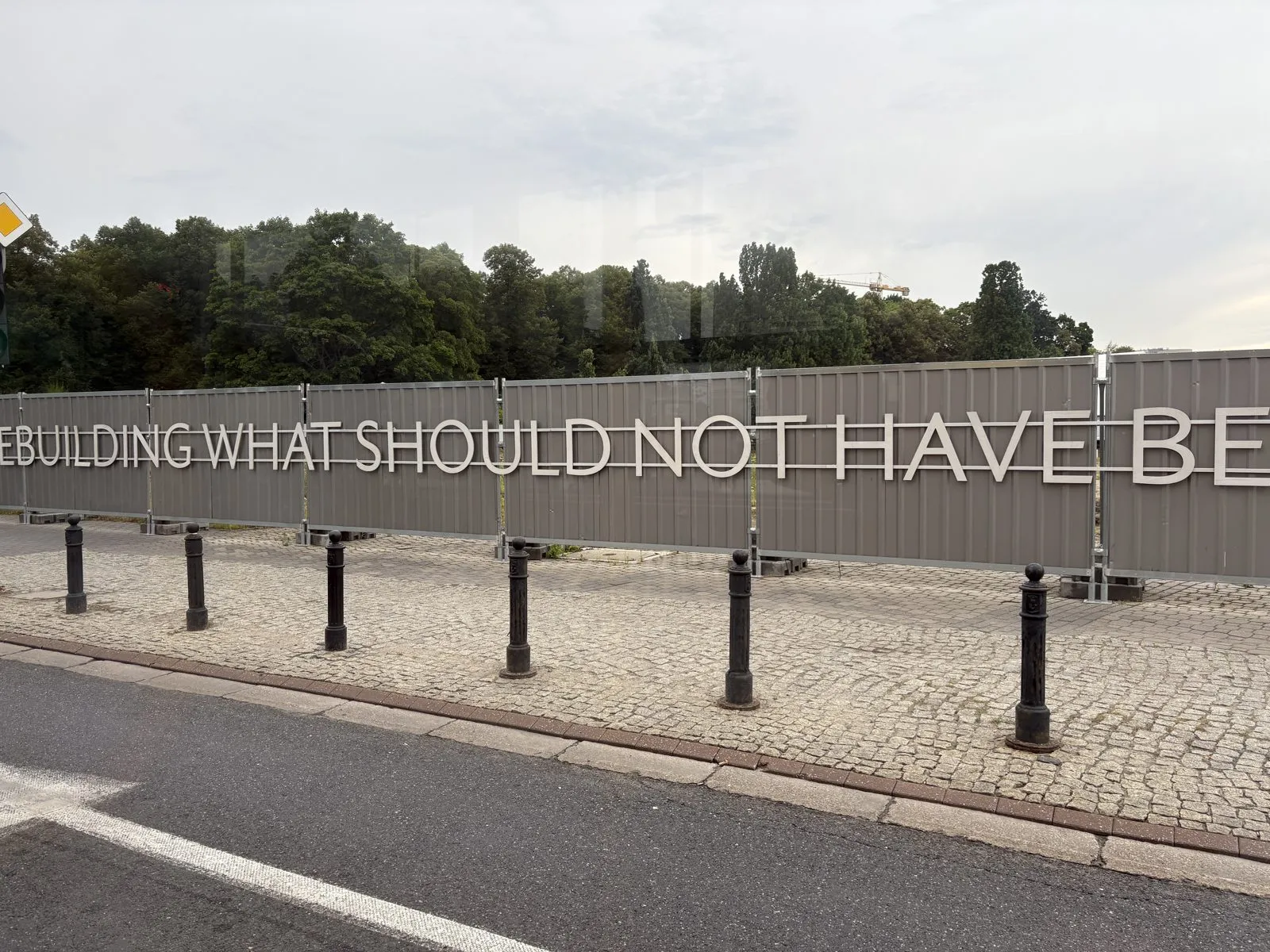 サスキ宮殿の再建工事の囲いに書かれた「REBUILDING WHAT SHOULD NOT HAVE BEEN DESTROYED」の文字