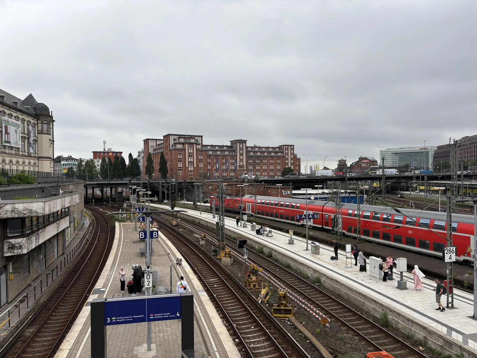 橋の上から見下ろしたハンブルク中央駅のホーム。赤い2階建て列車の奥に、レンガの建物が並ぶ
