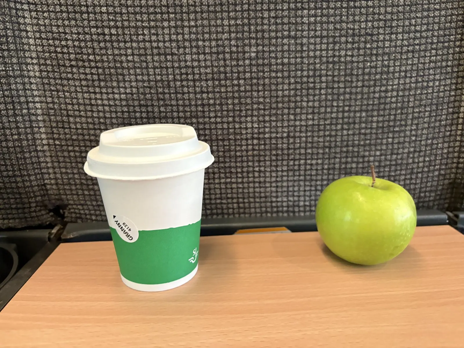 特急の座席のテーブルに置いた、コーヒーと青りんご